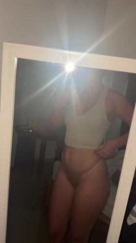 Woman takes mirror selfies in Dalung bedroom; Balinese offering spotted
