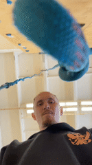 Man observes suspended climbing rope indoors in Sarapul, Russia