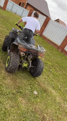 Young boy operates ATV on dirt path in rural Russia