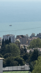 Woman enjoys balcony view of Sochi coastline