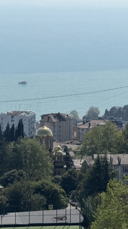 Woman enjoys balcony view of Sochi coastline
