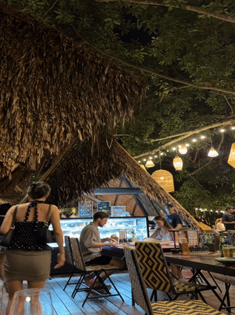 Evening diners gather at outdoor restaurant in Wichit, Thailand