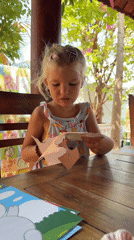 Child Does Paper Crafts Outdoors in Mũi Né Vietnam