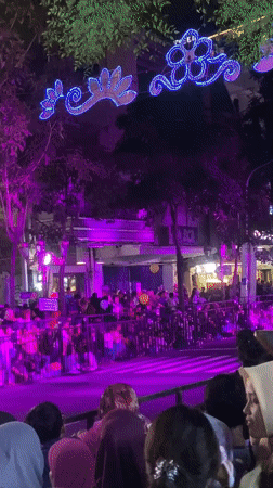 Crowd gathers on illuminated street in Surabaya, Indonesia