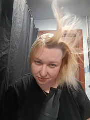 Woman blow-dries hair in Chaikovsky bathroom