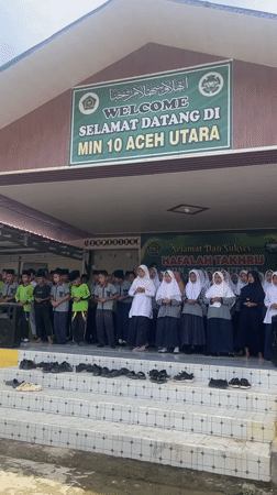 School children sing in uniforms on steps in Langnibong