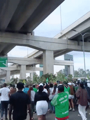 Football crowd gathers under Nairobi overpass with motorcycle riders