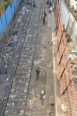 Mumbai railway corridors show urban density, waste accumulation