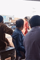 Three men gather near urban doorway in casual street scene