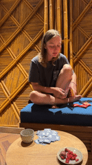 Woman sorts cards at wooden table on bench