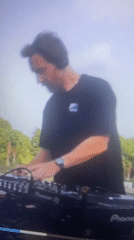 DJ performs outdoor set with Pioneer equipment amid palm trees