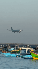 Kuta Beach at dusk: fishing boats, beachgoers, and planes overhead