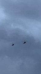 Helicopters fly over busy Đà Nẵng beaches at dusk