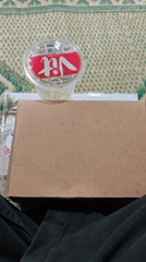 Everyday objects: a drink on a box, a patterned floor mat