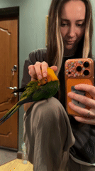 Woman takes selfie with colorful bird in Lobnya
