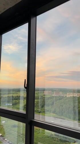 Suburban sunset viewed through a large window at golden hour