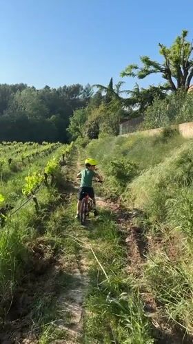 Boy rides red bike on dirt trail in Rousset