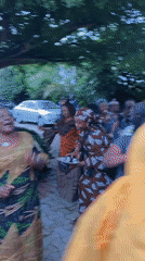 Community celebration with dancing and traditional attire in courtyard