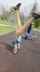 Man falls while attempting handstand at park exercise equipment