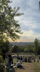 Prague park gatherings during sunset draw crowds to hillside