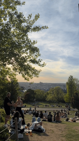 Prague park gatherings during sunset draw crowds to hillside