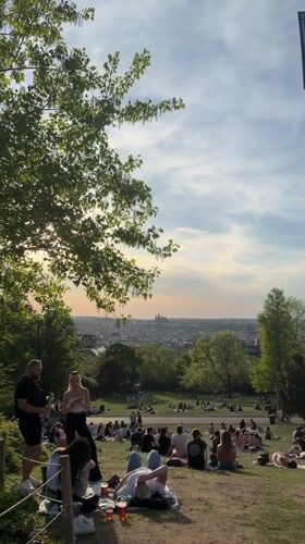 Prague park gatherings during sunset draw crowds to hillside