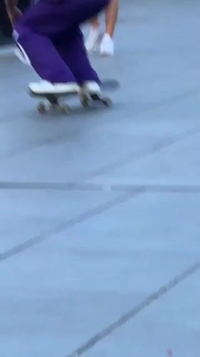Skateboarders session a Barcelona plaza at dusk