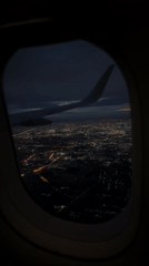 Nighttime aerial view of illuminated Bangkok captured from airplane window