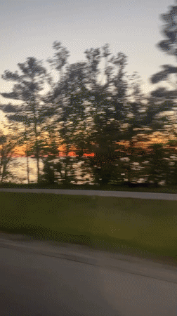 Sunrise captured over water from moving vehicle in Hayes Township