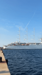 White cruise ship docked in calm Palamós harbor