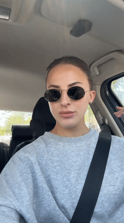 Woman adjusts appearance in car driver's seat in Holon