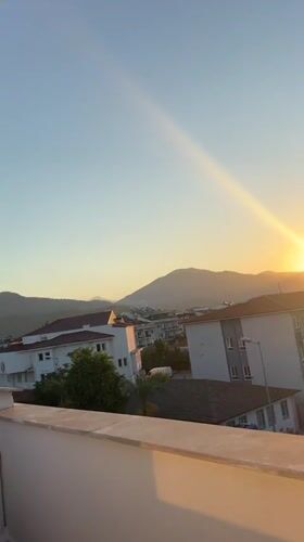 Fethiye balcony at golden hour, hills and rooftops at sunset