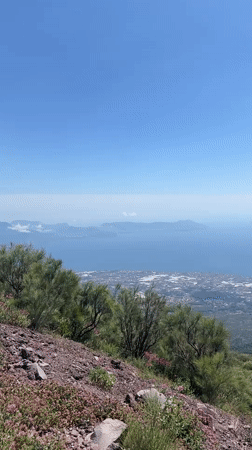Tourist documents Mount Vesuvius crater and Naples bay views
