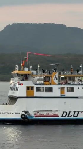 Melaya ferry terminal at dusk — boats, ramps, and port activity