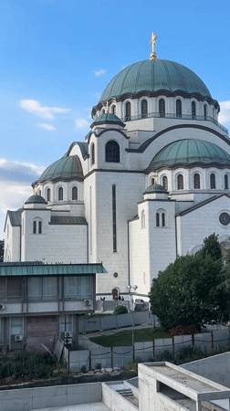 White cathedral with green domes observed in Belgrade district