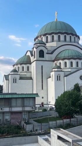 White cathedral with green domes observed in Belgrade district