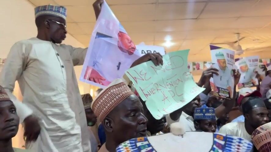 Political supporters gather with signs in Shaba, Nigeria