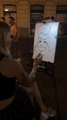 Street caricature artist at work on a Belgrade sidewalk, evening