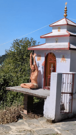 Man performs breathing exercises near temple in Haini, India