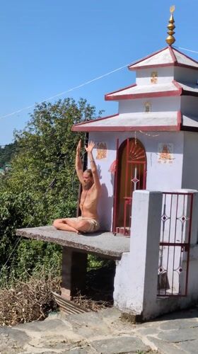 Man performs breathing exercises near temple in Haini, India