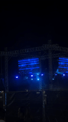 Nighttime concert in Tel Aviv, screens glowing blue
