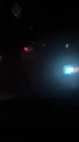 The video shows a night-time view from inside a car, looking out the windshield at other vehicles in a traffic jam. The brake lights of the cars ahead are illuminated, and the environment is dark.  The focus is on the vehicle directly in front, a white Mercedes-Benz C230, with its license plate visible. The footage is shaky.