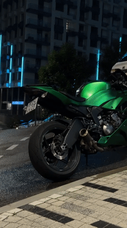 Nighttime street scene documented in Sochi featuring motorcycle, resident