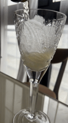 Person pours sparkling beverage into crystal glass