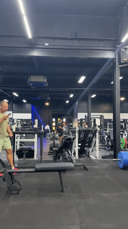 Man uses phone in early morning gym session