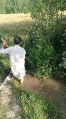 Man clears irrigation waterway in rural Pakistan