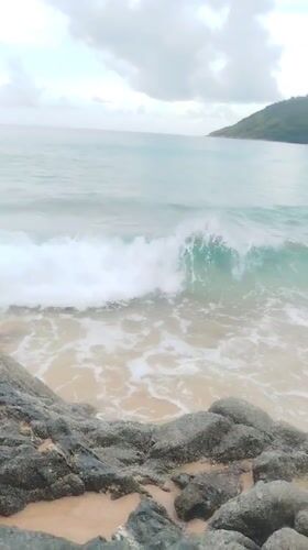 Casual morning at Rawai beach, rocky shores and overcast skies