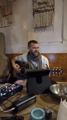 Street musician performs with acoustic guitar in Haini