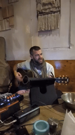Street musician performs with acoustic guitar in Haini