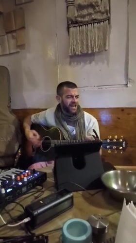 Street musician performs with acoustic guitar in Haini